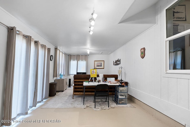 dining space featuring wooden walls and rail lighting