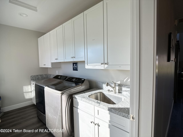 laundry area featuring cabinets, sink, washer and dryer, and dark hardwood / wood-style flooring