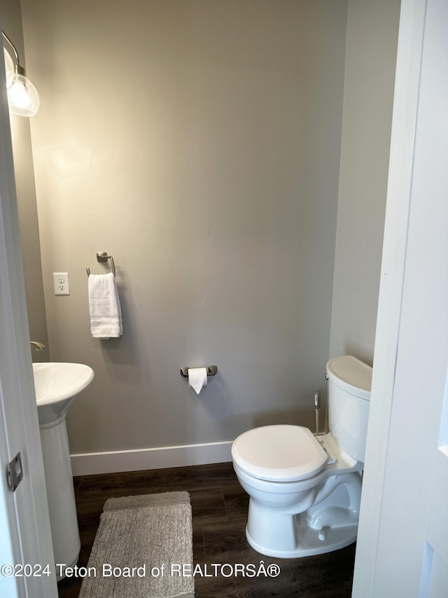 bathroom featuring hardwood / wood-style flooring and toilet