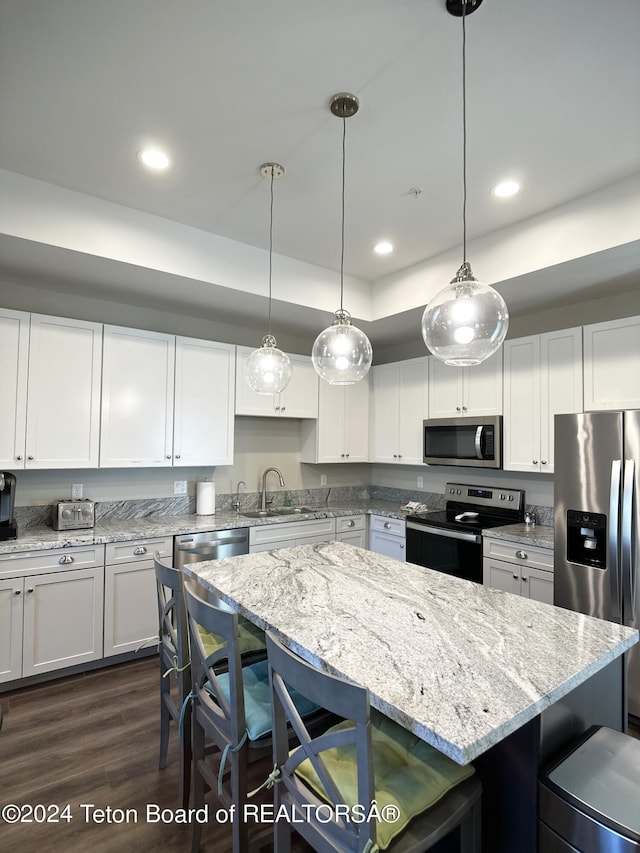 123 Creekside Ln, Swan Valley, ID 83449 - kitchen featuring stainless steel appliances, a kitchen bar, a sink, white cabinets, and a kitchen island