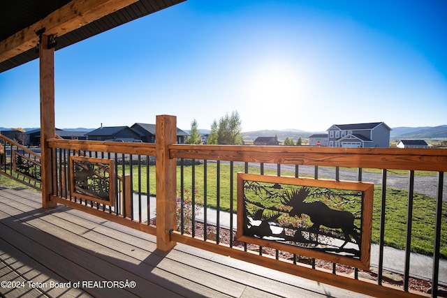 deck featuring a mountain view and a yard