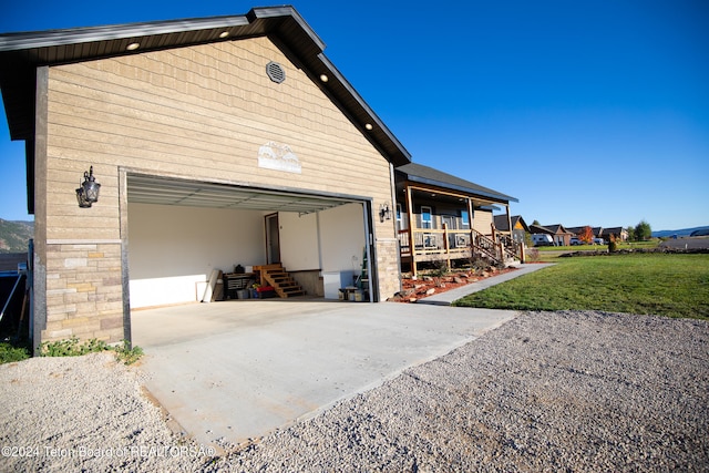 garage featuring covered porch and a yard