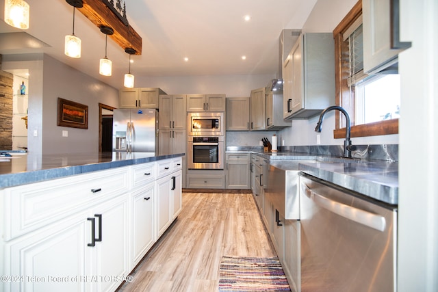 kitchen featuring pendant lighting, gray cabinets, stainless steel appliances, and light hardwood / wood-style flooring