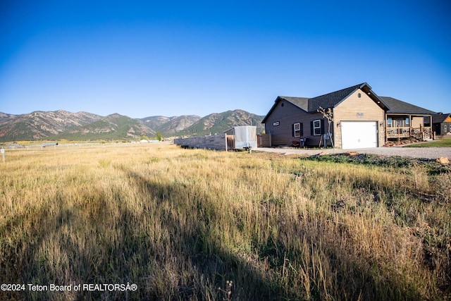 view of front of house featuring a garage, a mountain view, and a rural view