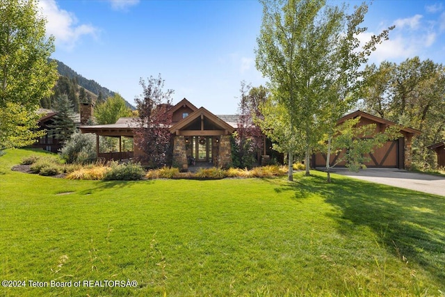 view of front of home featuring a mountain view and a front lawn