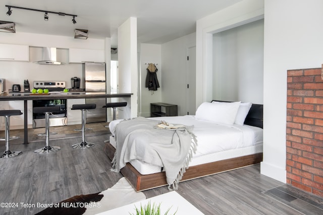 bedroom featuring hardwood / wood-style flooring and stainless steel refrigerator