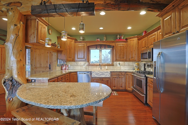 4120 W 9500 N, Tetonia, ID 83452 - kitchen featuring tasteful backsplash, stainless steel appliances, pendant lighting, a breakfast bar area, and dark hardwood / wood-style floors