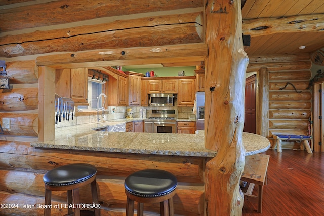 4120 W 9500 N, Tetonia, ID 83452 - kitchen featuring log walls, light stone countertops, kitchen peninsula, and stainless steel appliances