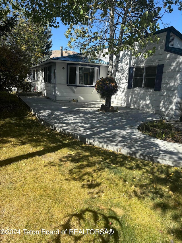 view of front of house with a front lawn and a patio area