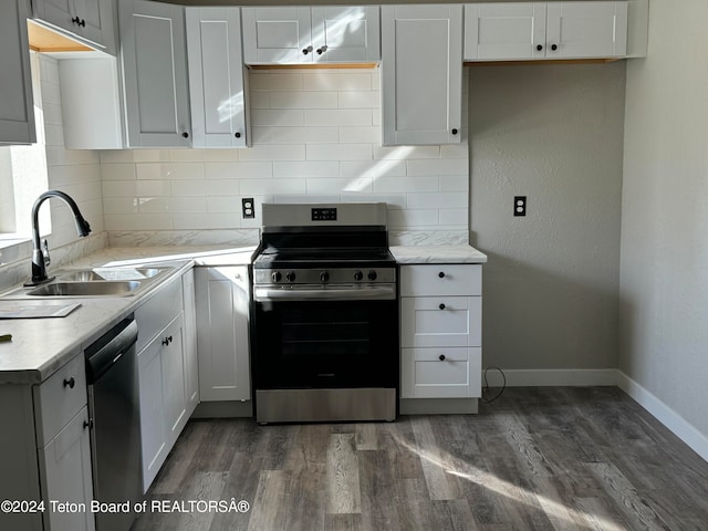 kitchen with sink, dark wood-type flooring, stainless steel appliances, and white cabinets