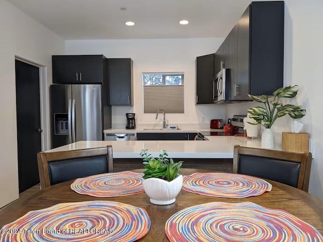 kitchen with kitchen peninsula, appliances with stainless steel finishes, and sink