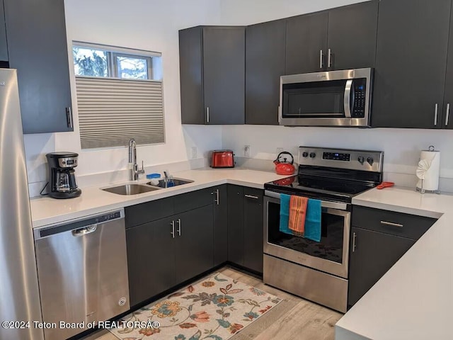 kitchen featuring light hardwood / wood-style floors, stainless steel appliances, and sink