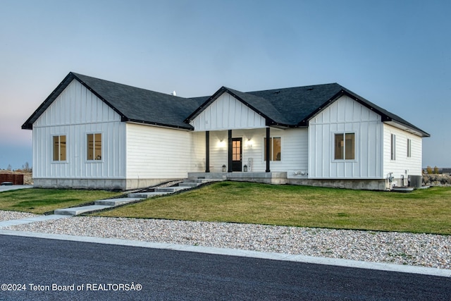 modern inspired farmhouse with a porch, a yard, and cooling unit