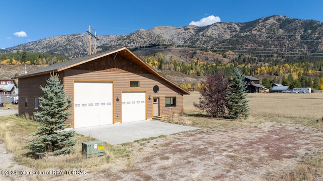 exterior space with an outdoor structure, a mountain view, and a garage