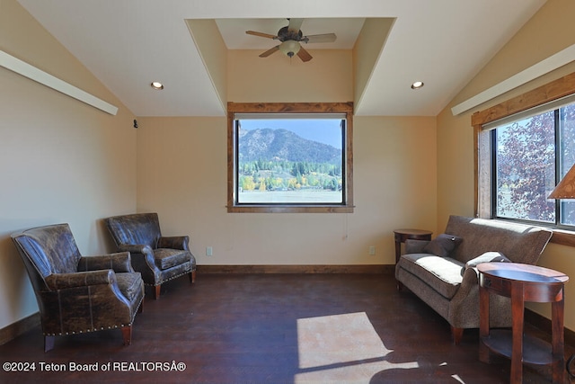 living area featuring vaulted ceiling, dark hardwood / wood-style flooring, a mountain view, and ceiling fan