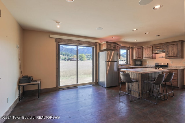 kitchen featuring a center island, stainless steel appliances, sink, dark hardwood / wood-style flooring, and a breakfast bar area