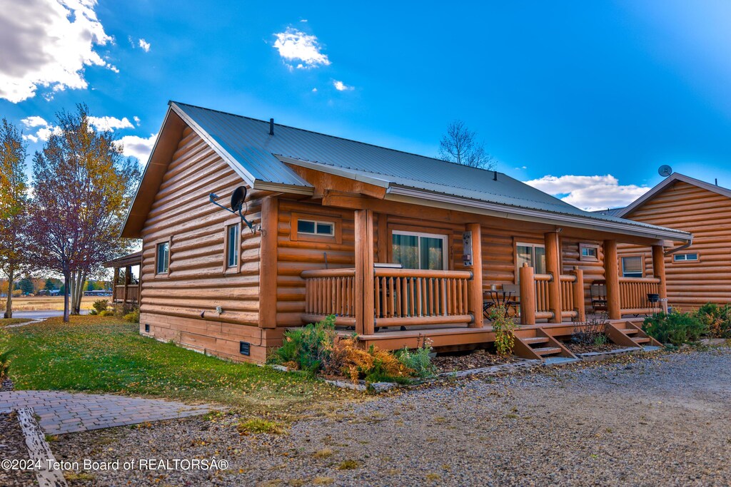 548 Canal St, Pinedale, WY 82941 - cabin with a porch, metal roof, and crawl space