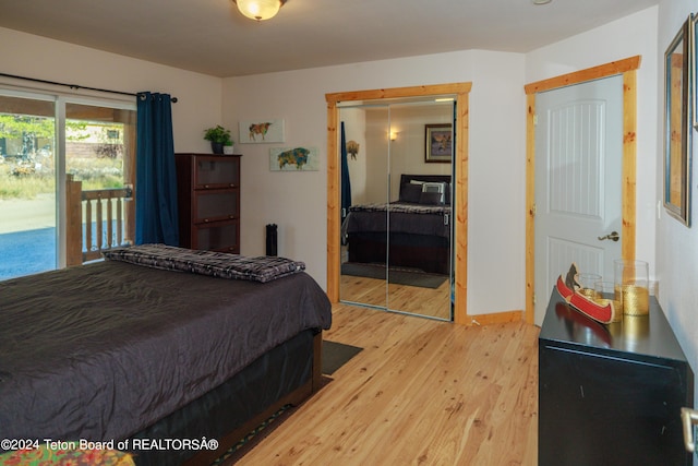 bedroom with wood-type flooring, a closet, and access to outside