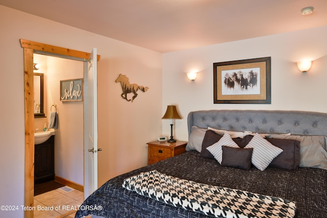 bedroom featuring light tile patterned flooring and ensuite bath