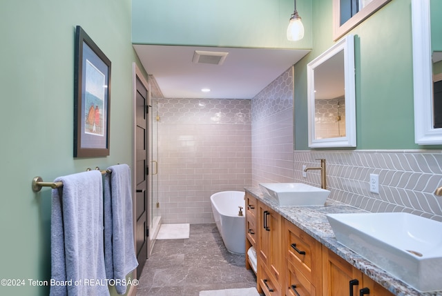 bathroom featuring tile walls, vanity, and shower with separate bathtub