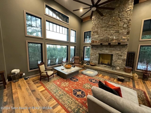 living room featuring a high ceiling, hardwood / wood-style flooring, a fireplace, and a wealth of natural light