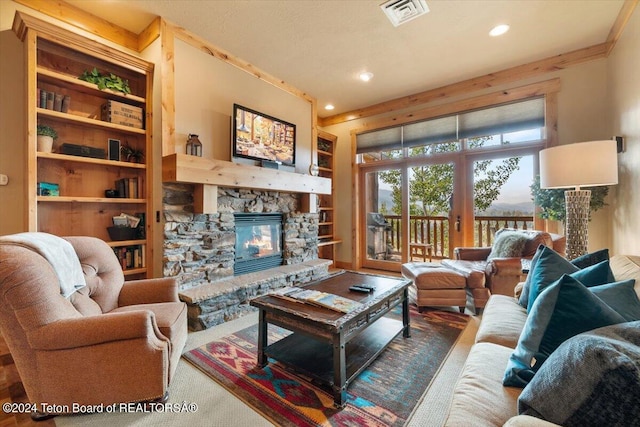 living room featuring a stone fireplace, built in features, carpet flooring, visible vents, and recessed lighting