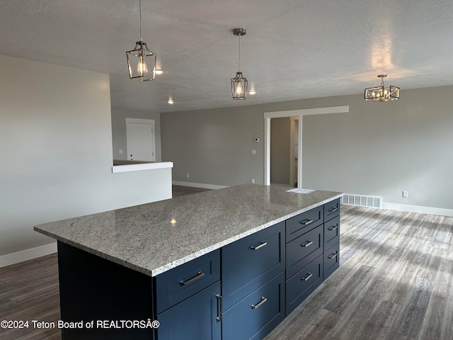 kitchen featuring pendant lighting, dark wood-type flooring, a textured ceiling, and a kitchen island