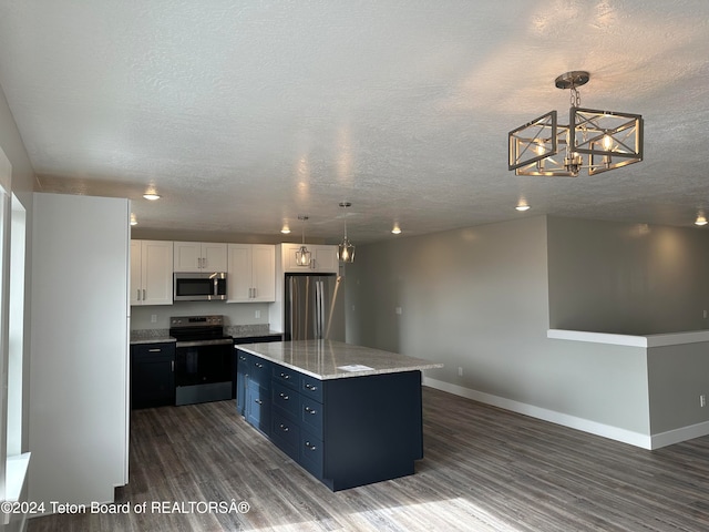 kitchen featuring white cabinetry, stainless steel appliances, hanging light fixtures, and a kitchen island