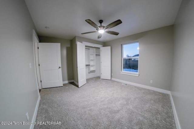 unfurnished bedroom with ceiling fan and light colored carpet