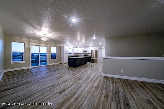 unfurnished living room featuring dark hardwood / wood-style floors and a textured ceiling