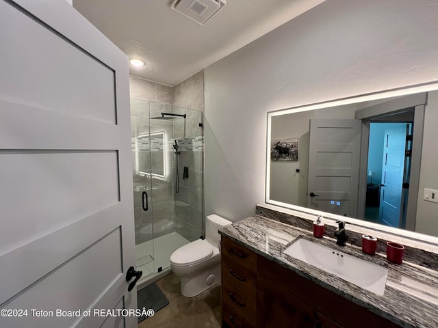 bathroom with toilet, walk in shower, vanity, and a textured ceiling