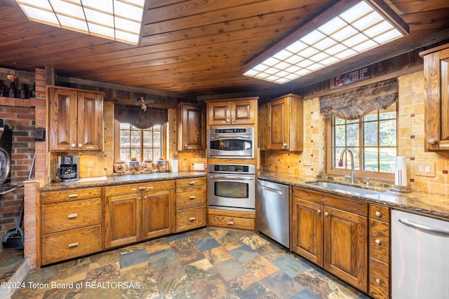 65 Bald Mountain Rd, Dubois, WY 82513 - kitchen featuring appliances with stainless steel finishes, a sink, brown cabinetry, stone countertops, and wood ceiling