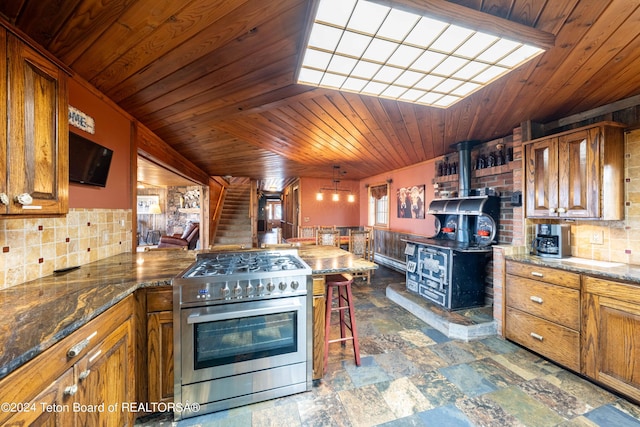 65 Bald Mountain Rd, Dubois, WY 82513 - kitchen with gas stove, wood ceiling, tasteful backsplash, brown cabinets, and a wood stove