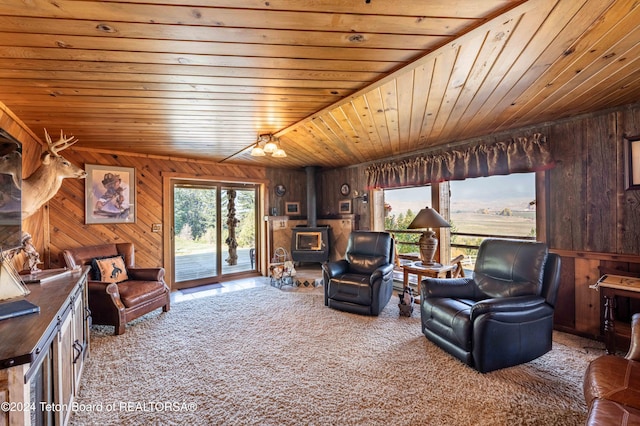 carpeted living room with a wood stove, wooden walls, and wood ceiling