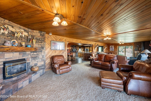 living room featuring wood walls, carpet flooring, wooden ceiling, vaulted ceiling, and a stone fireplace