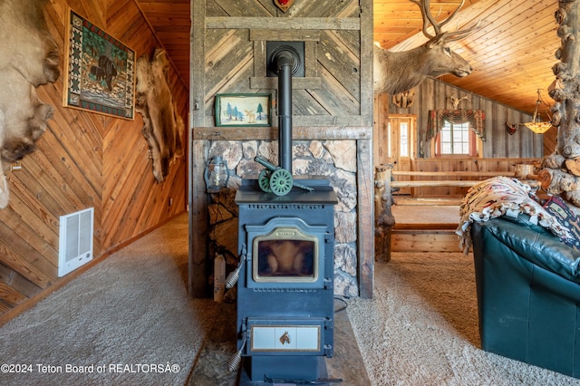 carpeted living room with wood walls, wooden ceiling, lofted ceiling, and a wood stove