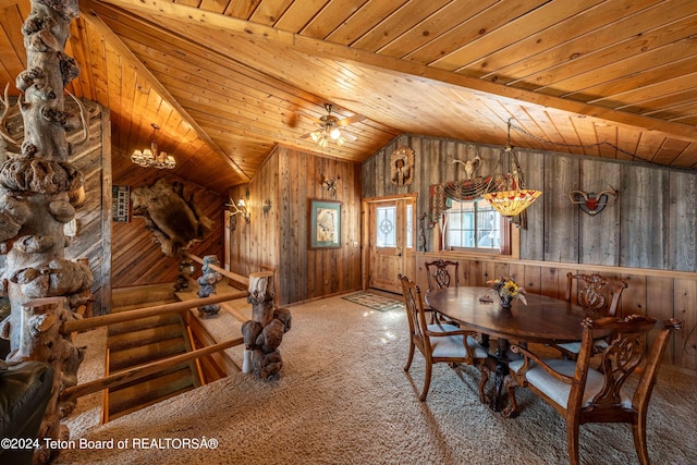 carpeted dining room with ceiling fan, lofted ceiling, wood walls, and wooden ceiling