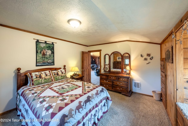 carpeted bedroom featuring a textured ceiling, lofted ceiling, and ornamental molding