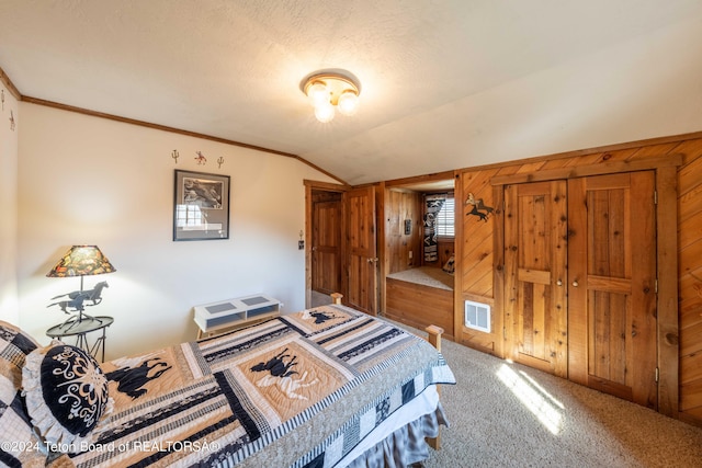 bedroom featuring ornamental molding, lofted ceiling, wood walls, and carpet