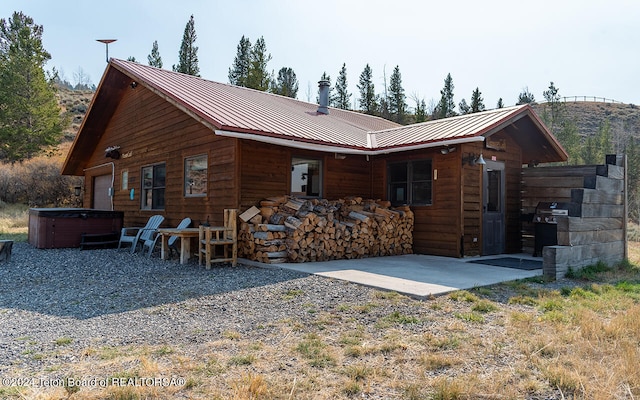 back of house with a patio and a hot tub