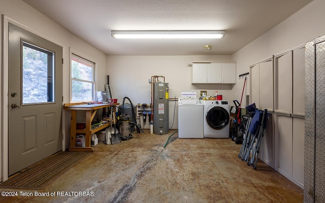 laundry room featuring washing machine and dryer, cabinets, electric water heater, and a textured ceiling