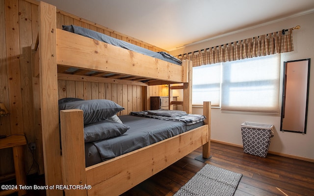 bedroom with wood walls and dark hardwood / wood-style flooring