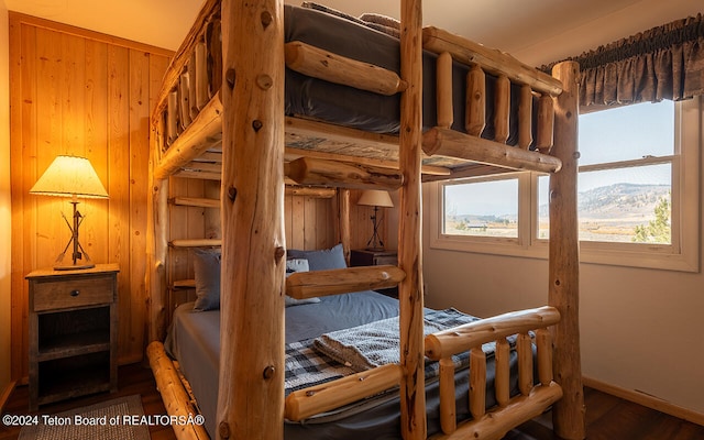 bedroom featuring dark wood-type flooring and wood walls