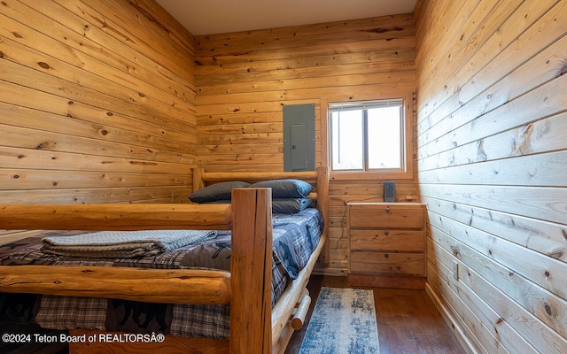 unfurnished bedroom with wood walls and dark hardwood / wood-style flooring