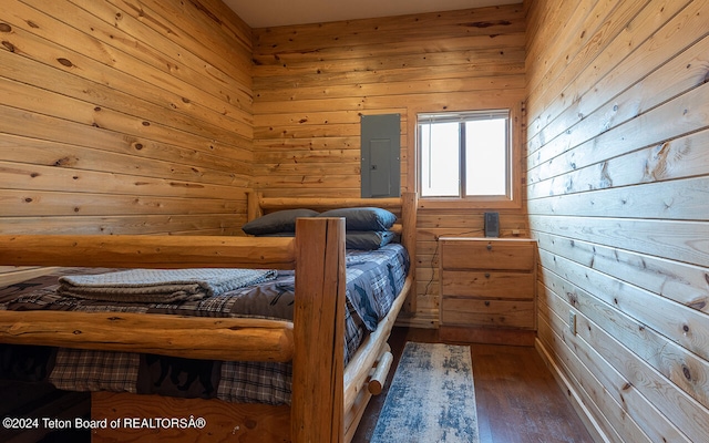 unfurnished bedroom featuring electric panel, wood walls, and dark wood-type flooring