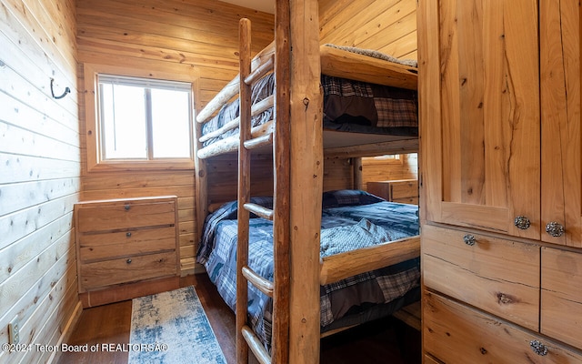 bedroom featuring wooden walls and dark hardwood / wood-style flooring