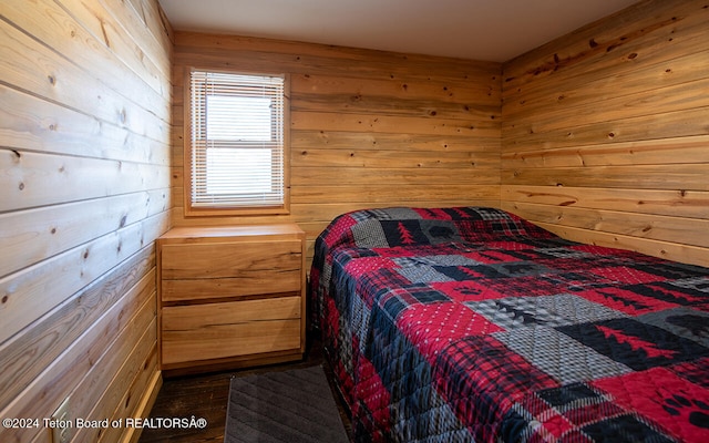 bedroom featuring hardwood / wood-style flooring and wood walls