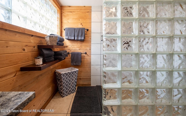 bathroom with tile patterned flooring and wooden walls