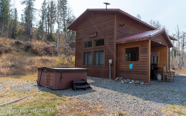 rear view of house with a hot tub