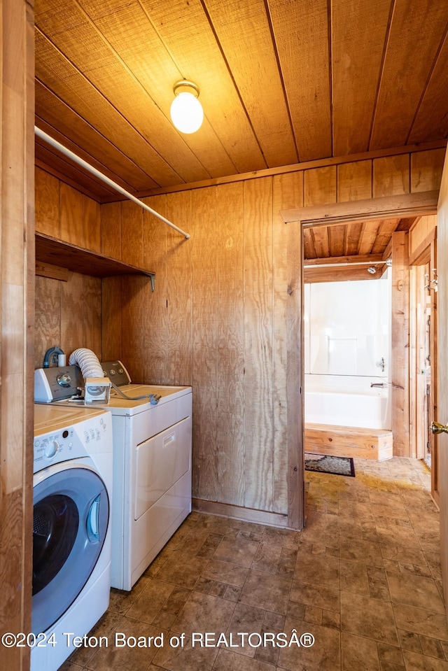 clothes washing area with wooden walls, washer and clothes dryer, and wooden ceiling